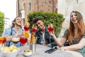 vrienden drinken gekleurde cocktail Bij buitenshuis bar foto