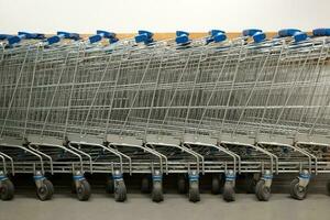 rij van boodschappen doen trolleys of karren in supermarkt. foto