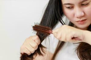 Aziatisch Dames zijn bezorgd over hun beschadigd haar- veroorzaken een gebrek van vertrouwen. haar- verlies behandeling concept, beschadigd haar, schoonheid salon. foto