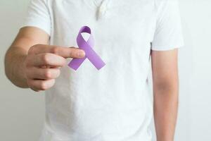 Internationale dag voor de eliminatie van geweld tegen Dames, hand- met paars lint symbool foto