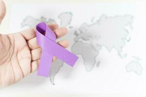 Internationale dag voor de eliminatie van geweld tegen Dames, hand- met paars lint symbool. foto