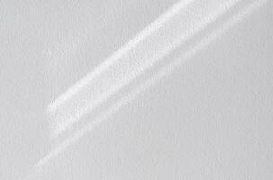 wit muur beton structuur met abstract laten vallen diagonaal schaduw. zonlicht bedekking Aan wit gips verf Aan beton vloer, licht effect voor monochroom foto, spot omhoog, affiche, muur kunst ontwerp presentatie foto