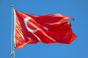 golvend Turks vlag. lucht achtergrond. vlag met ster en halve maan symbool foto