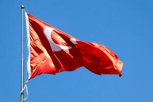 golvend Turks vlag. lucht achtergrond. vlag met ster en halve maan symbool foto