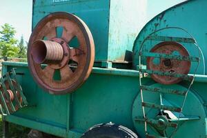 oud boerderij ploeg, verlaten boerderij implementeren in de dorp, verroest machines, lucht, gras en tuin, op wielen landbouw foto