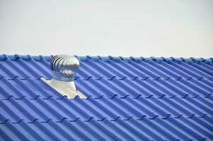 de blauw dak is uitgerust met een wind turbine naar ventileren de koeling lucht Aan de dak. foto