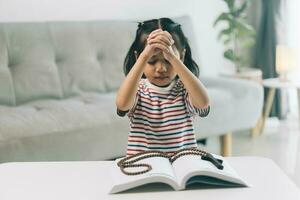 weinig meisje bidden in de ochtend.weinig Aziatisch meisje hand- bidden, handen gevouwen in gebed concept voor geloof, spiritualiteit en geloof. foto