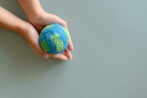 handen Holding aarde papier en water verf. concept van beschermen de wereld van globaal opwarming. duurzaamheid onderwerp naar opslaan de wereld. foto