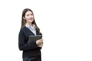 professioneel Aziatisch jong bedrijf vrouw in zwart pak glimlacht gelukkig terwijl ze werken en houdt tablet geïsoleerd Aan wit achtergrond. foto