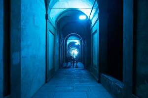 Bologna, Italië- juni 23, 2023-mensen wandeling Bij nacht onder de arcades leidend naar de heiligdom van san luca verlichte voor de eerste editie van de bologna arcades festival. foto