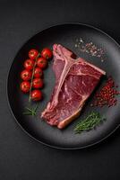 rauw sappig rundvlees t-bone steak met zout, specerijen en kruiden foto