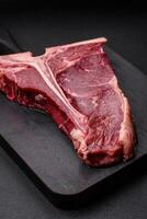 rauw sappig rundvlees t-bone steak met zout, specerijen en kruiden foto