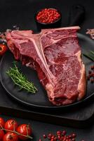 rauw sappig rundvlees t-bone steak met zout, specerijen en kruiden foto