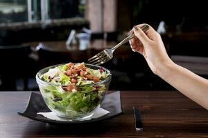 jong vrouw aan het eten heerlijk tonijn salade in een luxe restaurant, laag in calorieën voedzaam maaltijd - vegetarisch foto