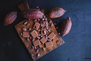 chocolade en cacaobonen met cacao op een zwarte achtergrond