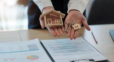 huismodel en sleutel op tafel voor financiën en bankwezen concept.home aankoop hypotheek concept. foto