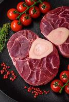 vers rauw rundvlees steak met bot of ossobuco met zout, specerijen en kruiden foto