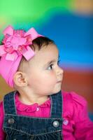 portret van een mooi tien maanden baby meisje Aan een kleurrijk achtergrond. vroeg stimulatie voor peuters concept. foto