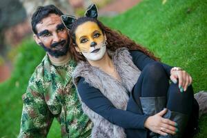 jong paar vervelend wolf en houthakker kostuums. echt familie hebben pret terwijl gebruik makend van kostuums van de weinig rood rijden kap verhaal in halloween. foto