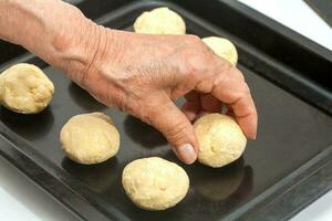 pandebono voorbereiding. plaatsen rauw pandebonos Aan een bakken vel foto