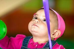 mooi tien maanden baby meisje spelen met kleurrijk ballen. vroeg stimulatie voor peuters concept. foto