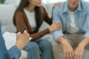 paar houden hand- ondersteuning elk terwijl bespreken familie problemen met psychiater. man moedigt aan en empathie vrouw lijdt depressie. psychologisch, opslaan scheiding, hand- in hand- samen, vertrouwen, zorg foto