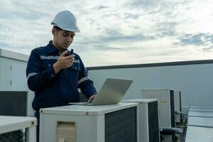 Aziatisch onderhoud ingenieur werk Aan de dak van fabriek. aannemer inspecteren compressor systeem en plannen installatie van lucht staat systemen in bouw. technologie, walky spraakzaam, onderhoud foto