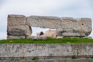 ruïnes van de oude tempel van olympische zeus in athene met de akropolisheuvel op de achtergrond
