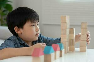 gelukkig Azië kinderen Speel en leren speelgoed- blokken.familie is gelukkig en opgewonden in de huis. dochter hebben pret uitgeven tijd, werkzaamheid, ontwikkeling, iq, gelijk, meditatie, brein, spieren, essentieel vaardigheden. foto