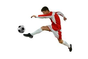 voetbal speler schopt de voetbal in de lucht door jumping foto