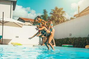 groep van vrienden in zwempak genieten in een zwemmen zwembad foto