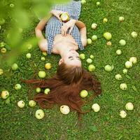 een vrouw houdende Aan de gras met appels foto