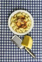 bord van eigengemaakt gnocchi met geraspt kaas Aan de tafel foto