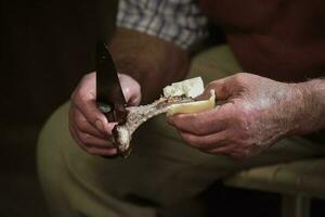 gaucho snijdend een geroosterd rib, Patagonië Argentinië foto