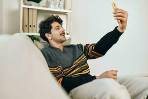 Mens huis bericht verbinding levensstijl telefoon lezing communicatie typen technologie selfie sofa foto