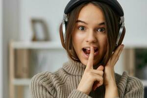 oortelefoons vrouw leerling muziek- gelukkig binnen- jong huis typen Kaukasisch hoofdtelefoons foto