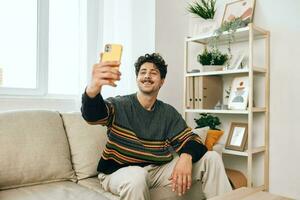 kamer Mens huis bericht communicatie jong levensstijl sofa Holding selfie leven technologie telefoon typen vrije tijd foto