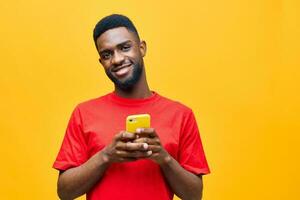 telefoon Mens typen achtergrond zwart mobiel geïsoleerd technologie Afrikaanse gelukkig jong geel foto