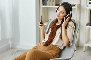 stoel muziek- glimlach gelukkig meisje levensstijl telefoon meditatie oortelefoons tiener- foto