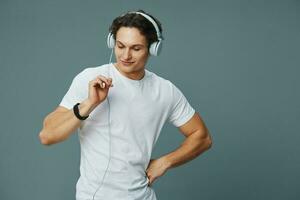 portret Mens jong persoon luister muziek- gelukkig t-shirt levensstijl studio oortelefoons foto
