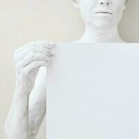 blanco ontwerp poster sjabloon. vrouw gedekt met wit verf Holding een papier. focus Aan handen. foto