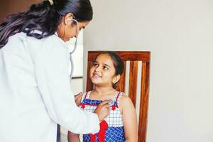 Indisch dokter met weinig Indisch meisje foto