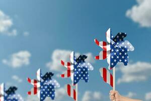 hand- Holding wind turbine patriottisch van Verenigde Staten van Amerika over- blauw lucht achtergrond. foto