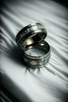 een paar van bruiloft ringen zittend Aan top van een bed. ai gegenereerd foto
