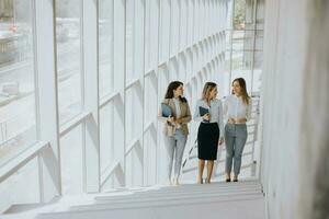 drie jong bedrijf Dames wandelen Aan trap in de kantoor gang foto