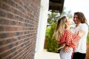 glimlachen jong paar in liefde in voorkant van huis steen muur foto