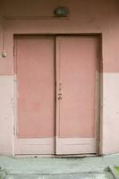 oud houten scheef roze deuren.entree naar de gebouw. foto