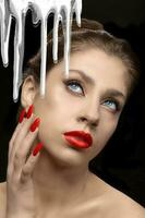 een wit gezicht room stromen tegen de achtergrond van een mooi meisje met rood lippen en nagels. foto