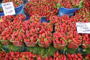 rijp rood aardbeien in een plastic kom verkoop Bij winkel foto
