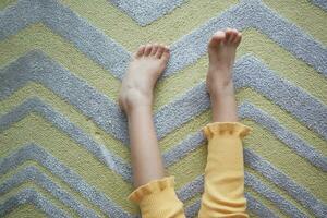 top visie van droog kind voeten Aan zacht tapijt foto